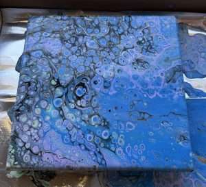 Beginner acrylic paint pouring canvas featuring dense blue, purple, and black cells with a fluid art technique learned at Paint Pour Academy