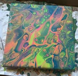 Vibrant beginner paint pour canvas in neon green, hot pink, and orange with bold fluid art cells created at a Paint Pour Academy in-person class