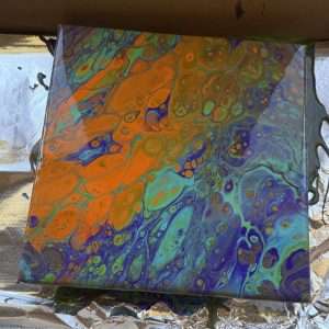 Student acrylic pour painting with a dramatic split of warm orange and cool teal and purple, showing detailed fluid art cells